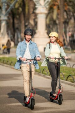 a man and a woman riding their respective segway ninebot electric scooters