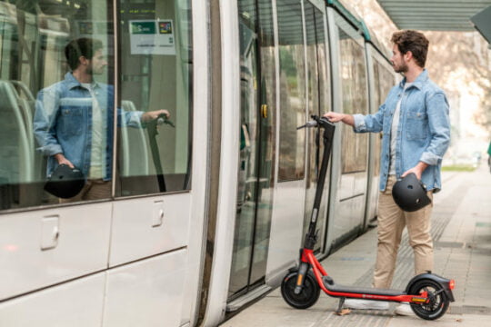 a man boarding a train with his segway ninebot d18u kickscooter